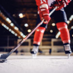 Close up of hockey player skating with stick and puck.