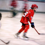 young boy playing ice hockey on the rink