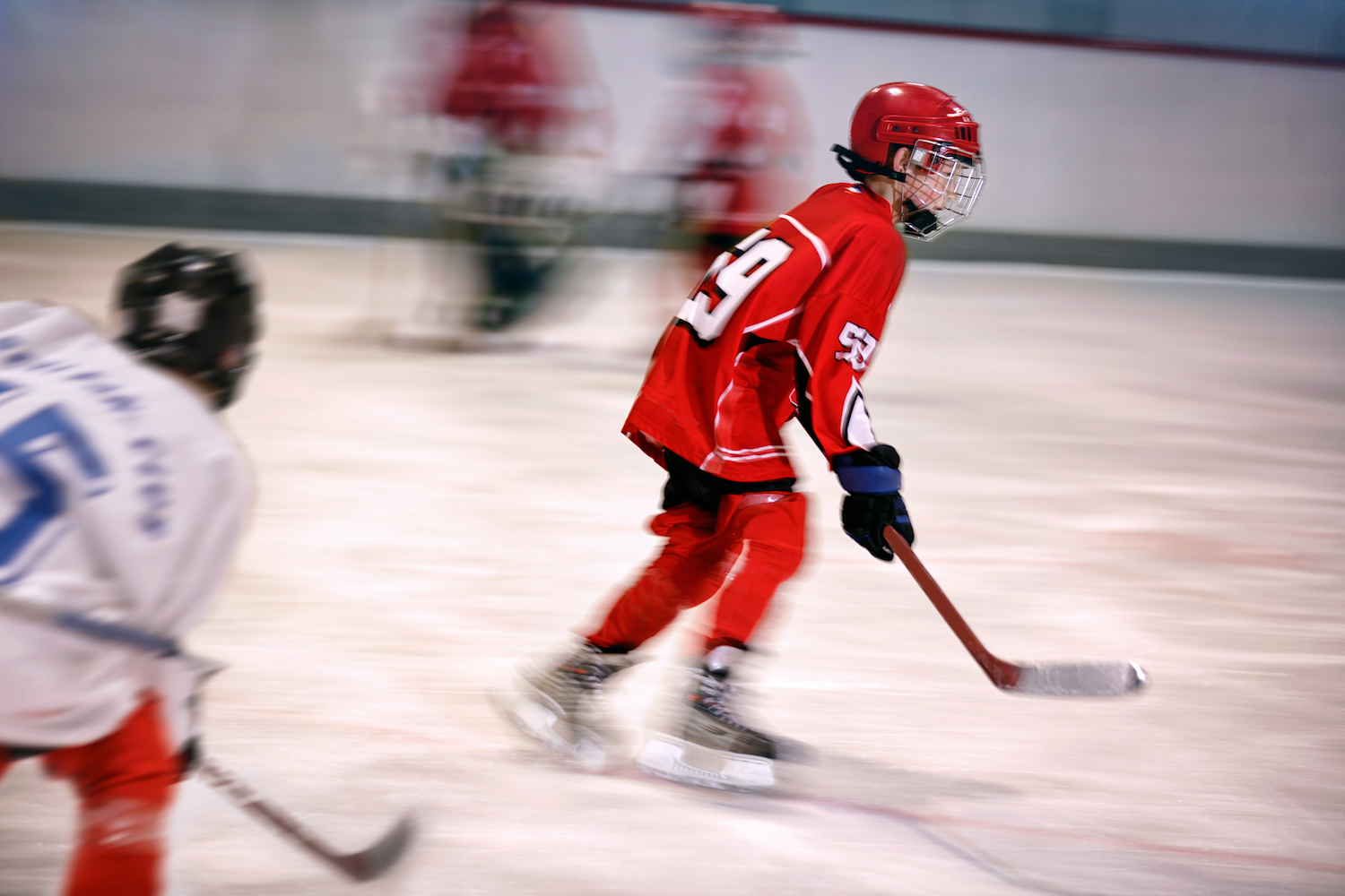 young boy playing ice hockey on the rink